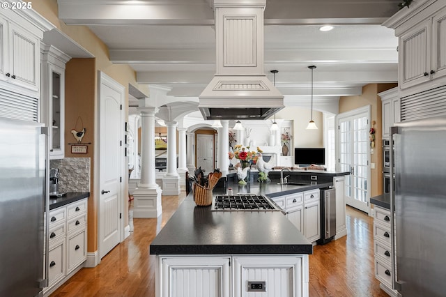 3545 Eagle Crest Rd NW, Salem, OR 97304 - kitchen featuring decorative columns, stainless steel appliances, dark countertops, a center island, and beam ceiling