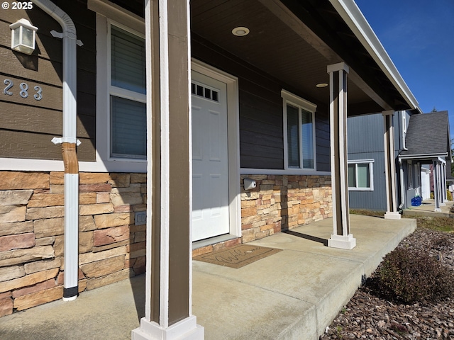 property entrance with a porch and stone siding