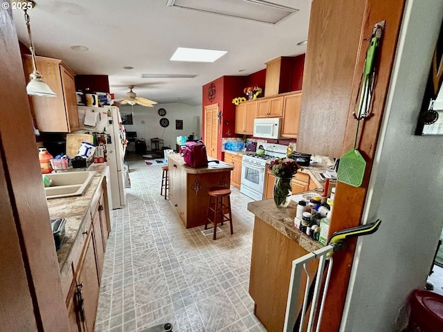 681 NW 9th St, Warrenton, OR 97146 - kitchen featuring white appliances, light brown cabinets, a sink, a kitchen breakfast bar, and ceiling fan