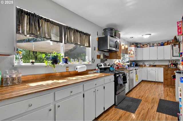 1224 Coal Creek Rd, Longview, WA 98632 - kitchen featuring stainless steel appliances, light wood-style floors, white cabinets, and butcher block countertops