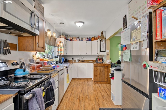 1224 Coal Creek Rd, Longview, WA 98632 - kitchen with appliances with stainless steel finishes, light wood-style flooring, white cabinets, and a sink