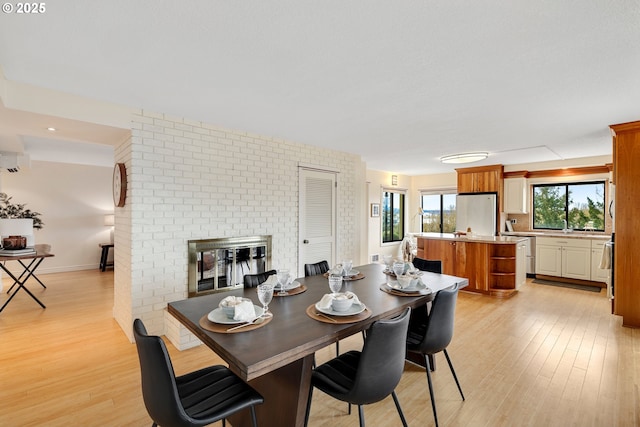 dining room with a fireplace and light hardwood / wood-style floors