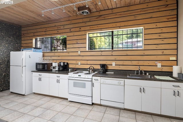 kitchen featuring white appliances, sink, white cabinetry, wood walls, and wooden ceiling