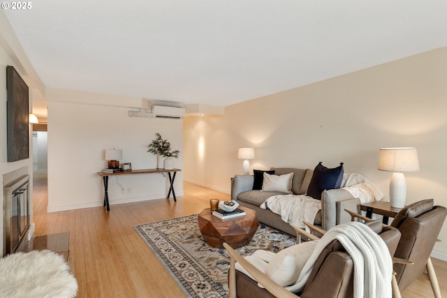 living room featuring a wall mounted air conditioner and light hardwood / wood-style flooring