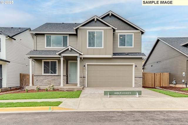 craftsman inspired home with board and batten siding, stone siding, fence, and concrete driveway