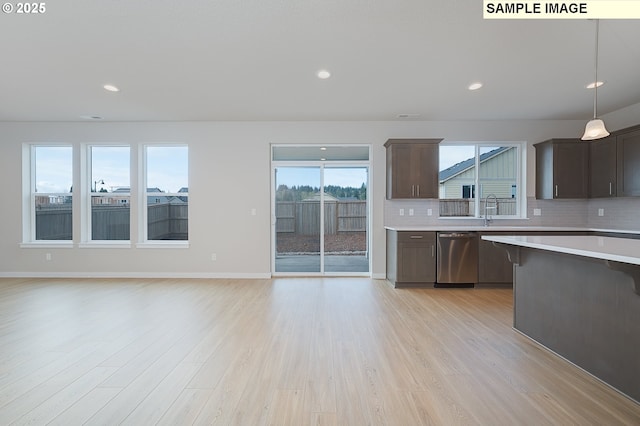 kitchen with dark brown cabinetry, light wood finished floors, dishwasher, light countertops, and backsplash