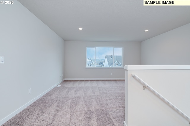 empty room with light carpet, baseboards, and recessed lighting