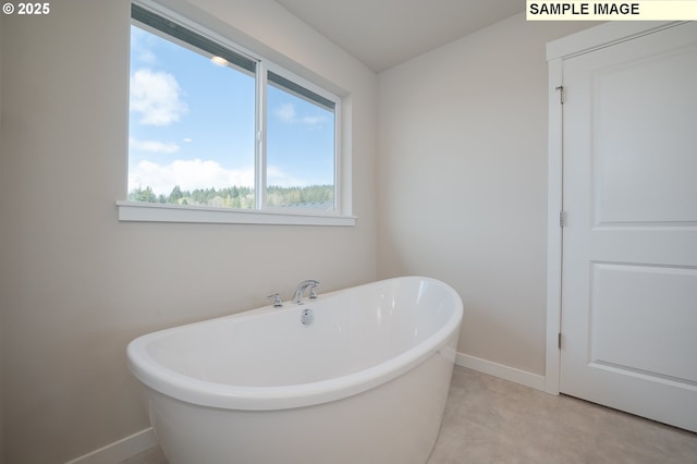 bathroom with a freestanding tub and baseboards