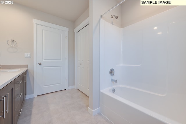 full bath featuring  shower combination, vanity, and baseboards