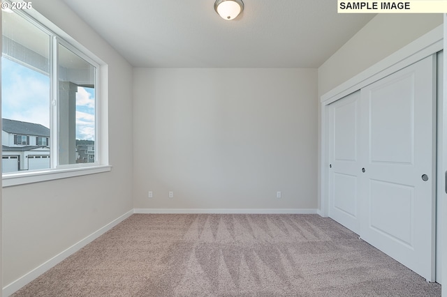 unfurnished bedroom featuring carpet, a closet, and baseboards