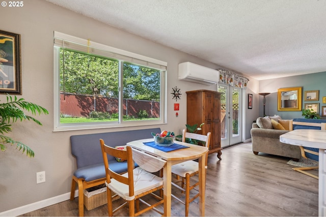 dining area featuring french doors, a textured ceiling, plenty of natural light, and a wall mounted AC