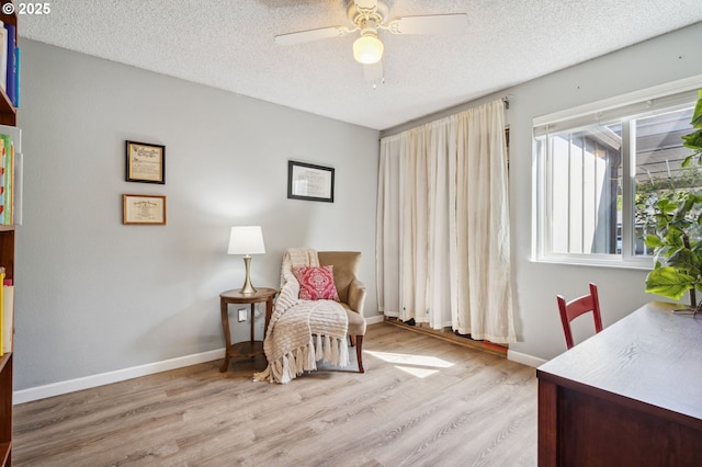 sitting room featuring a textured ceiling, baseboards, a ceiling fan, and wood finished floors