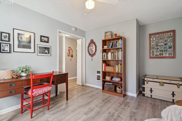 office space with baseboards, a ceiling fan, a textured ceiling, and wood finished floors