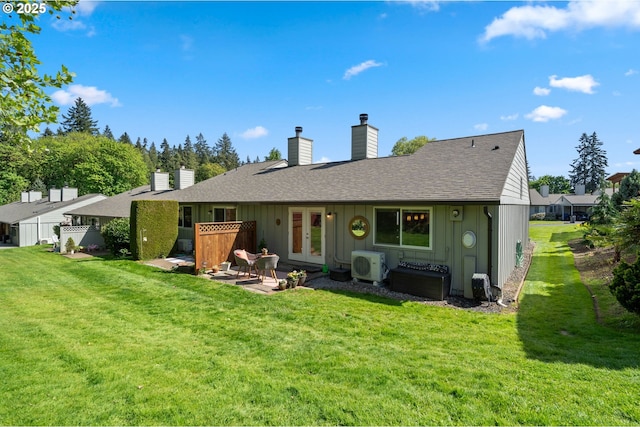 rear view of house with board and batten siding, a lawn, ac unit, and french doors