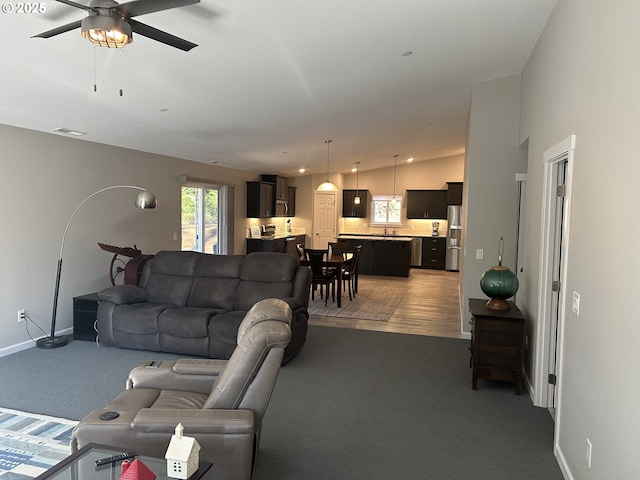 living room featuring ceiling fan, carpet, and lofted ceiling