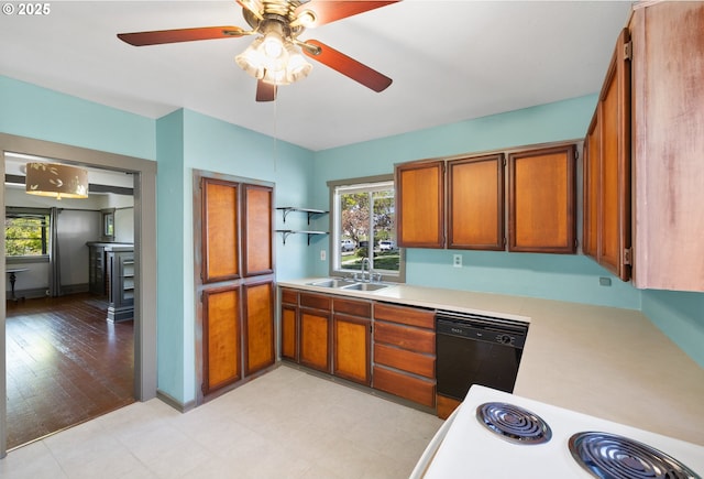 kitchen featuring a sink, black dishwasher, light countertops, range, and brown cabinetry