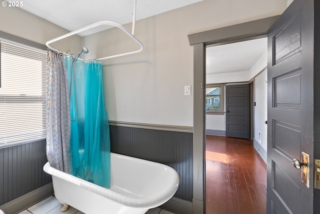 full bath featuring wood finished floors and shower / bath combo with shower curtain