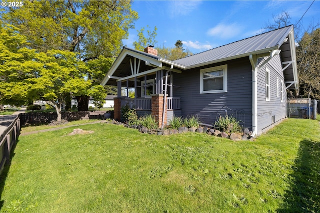 view of front of property with fence private yard, metal roof, a chimney, and a front yard