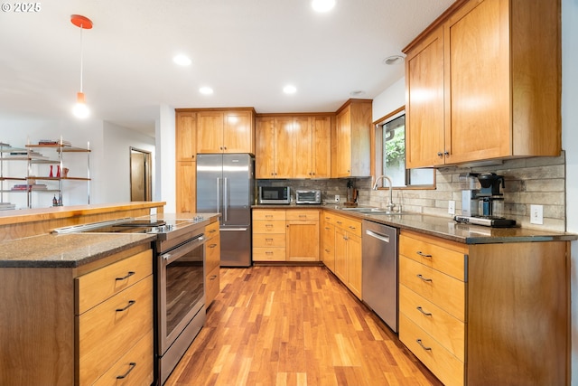 2345 NE Ridgewood Dr, Portland, OR 97212 - kitchen with appliances with stainless steel finishes, a sink, light wood-style flooring, tasteful backsplash, and decorative light fixtures