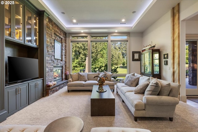 25003 NW 4th Ct, Ridgefield, WA 98642 - living room with carpet floors, a stone fireplace, a raised ceiling, and recessed lighting