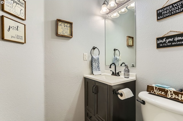 half bath featuring toilet and vanity