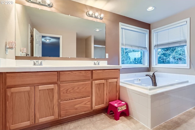 bathroom featuring double vanity, tile patterned flooring, a sink, and a bath