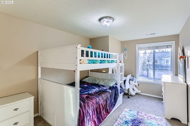 carpeted bedroom with baseboards and a textured ceiling