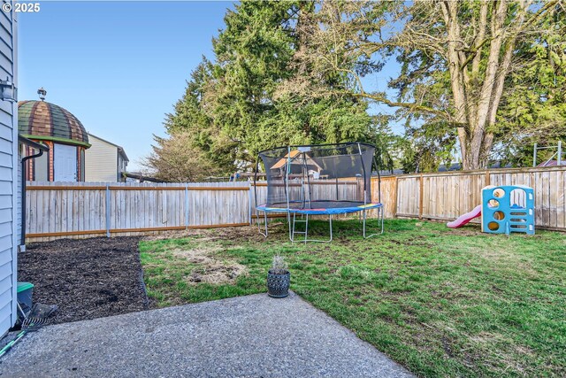 view of yard featuring a trampoline and a fenced backyard