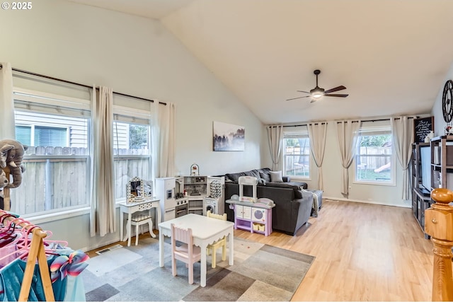 living area with ceiling fan, high vaulted ceiling, visible vents, and light wood-style flooring