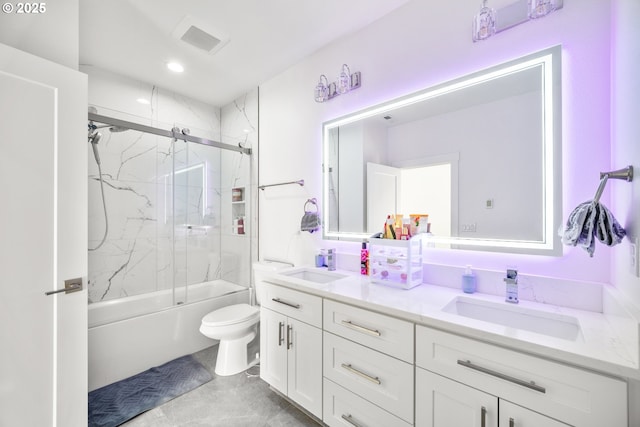 bathroom with a sink, bath / shower combo with glass door, toilet, and double vanity