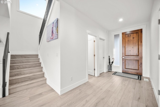 entryway with stairs, recessed lighting, baseboards, and light wood finished floors