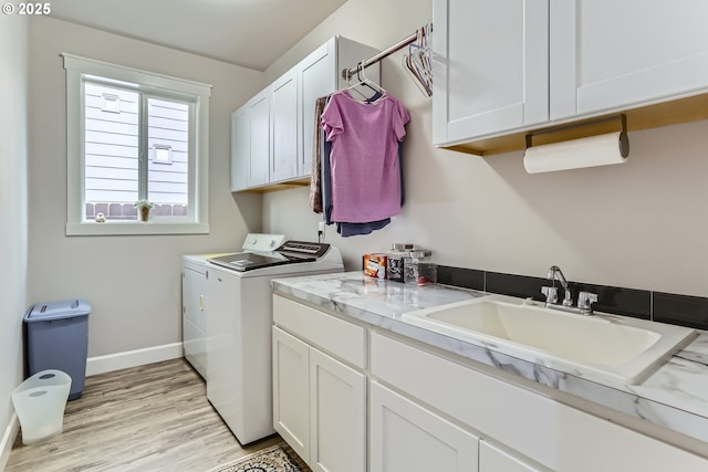 12024 NE 109th St, Vancouver, WA 98662 - laundry area with baseboards, washing machine and clothes dryer, light wood-style floors, cabinet space, and a sink