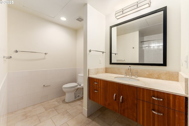 333 NW 9th Ave Unit 902, Portland, OR 97209 - full bath featuring toilet, tile walls, vanity, a wainscoted wall, and tile patterned floors