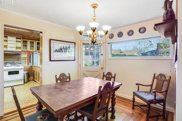 dining area featuring crown molding, baseboards, and a notable chandelier
