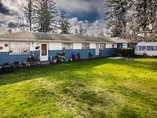 rear view of property featuring a yard