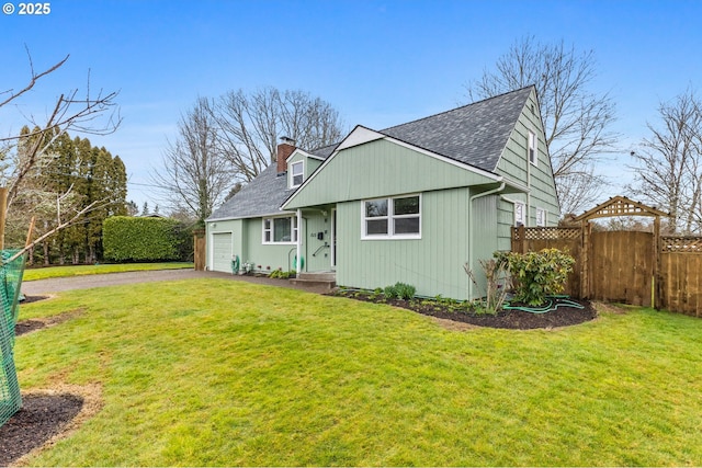 view of front facade with aphalt driveway, a front yard, roof with shingles, and fence