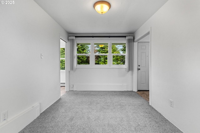 unfurnished room featuring carpet and a baseboard radiator