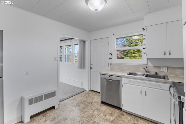 kitchen featuring radiator heating unit, light countertops, a wealth of natural light, stainless steel appliances, and a sink