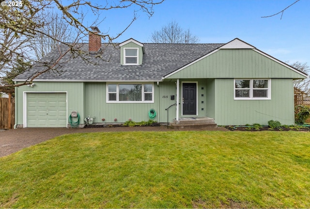 view of front of property featuring a front lawn, fence, aphalt driveway, a chimney, and a garage