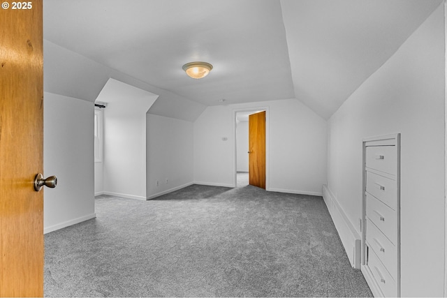 additional living space featuring baseboards, carpet, and vaulted ceiling