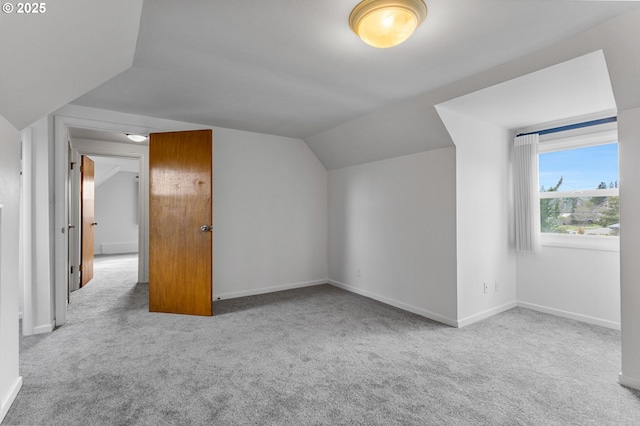 additional living space featuring lofted ceiling, carpet flooring, and baseboards