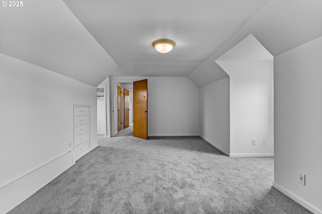 additional living space with carpet flooring, baseboards, and vaulted ceiling