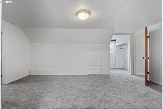 additional living space with vaulted ceiling, baseboards, and carpet floors