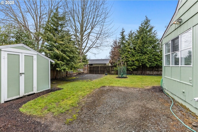 view of yard with an outbuilding, a shed, and a fenced backyard