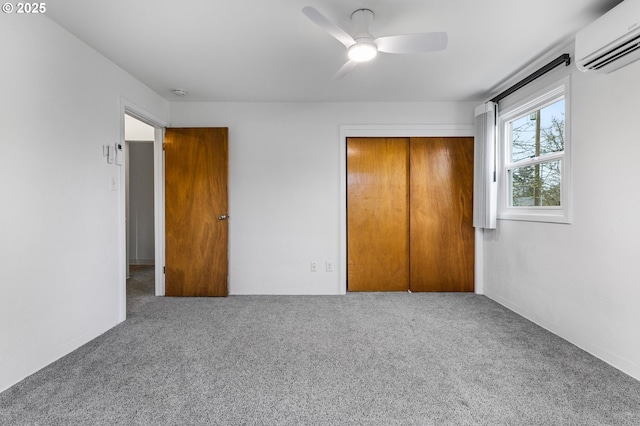 unfurnished bedroom featuring a closet, a ceiling fan, carpet, and a wall unit AC