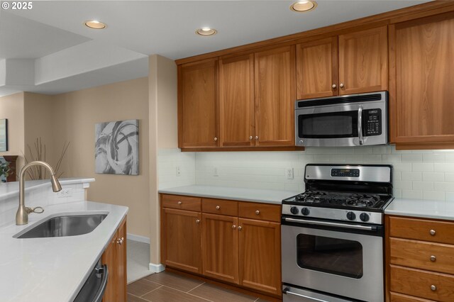4873 NW Promenade Ter Unit 122, Portland, OR 97229 - kitchen featuring appliances with stainless steel finishes, brown cabinets, light countertops, and recessed lighting