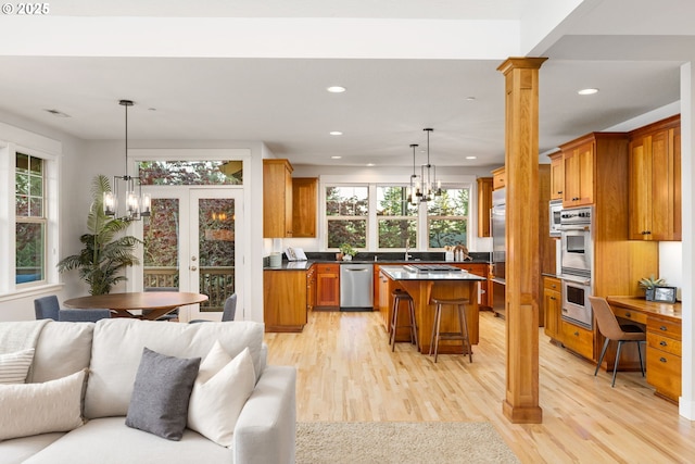 19375 SW Eastside Rd, Lake Oswego, OR 97034 - kitchen featuring stainless steel appliances, a chandelier, open floor plan, brown cabinetry, and recessed lighting