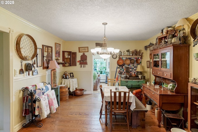 4269 Victor Point Rd, Silverton, OR 97381 - dining area with a chandelier, hardwood / wood-style flooring, a textured ceiling, and ornamental molding