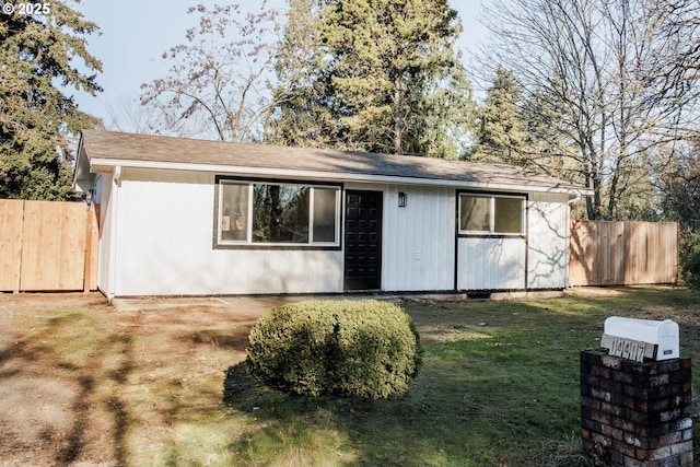 view of front of home with a front yard and fence