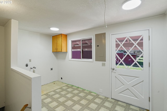 laundry room featuring electric dryer hookup, electric panel, cabinets, washer hookup, and a textured ceiling